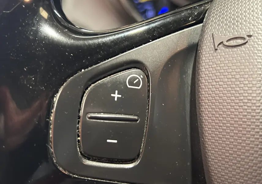 Gros plan sur les commandes de réglage du régulateur de vitesse au volant d'un Renault Captur gris diesel de 2015.