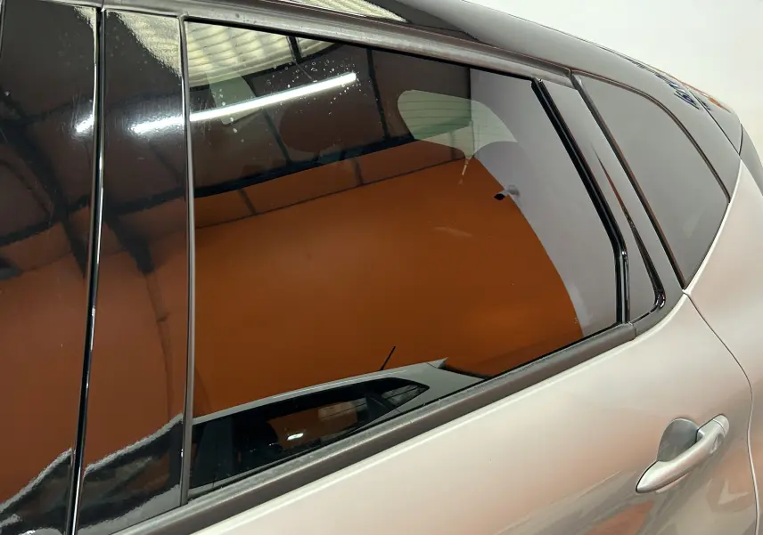 Vue latérale côté droit du Renault Captur gris 2015, mettant en valeur la porte arrière et la vitre teintée.