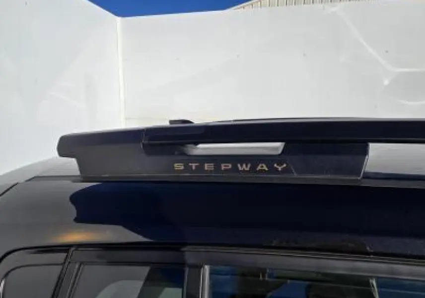 Gros plan sur la barre de toit noire nacrée d'une Dacia Sandero Stepway 2025 avec inscription Stepway brun cuirvré.