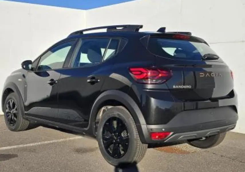 Vue 3/4 arrière droite d'une Dacia Sandero Stepway 2025 noir nacré avec jantes noires et barres de toit
