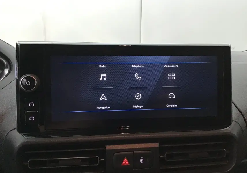Écran tactile central du tableau de bord du Peugeot Partner 2025 affichant les menus radio, téléphone, navigation et réglages.