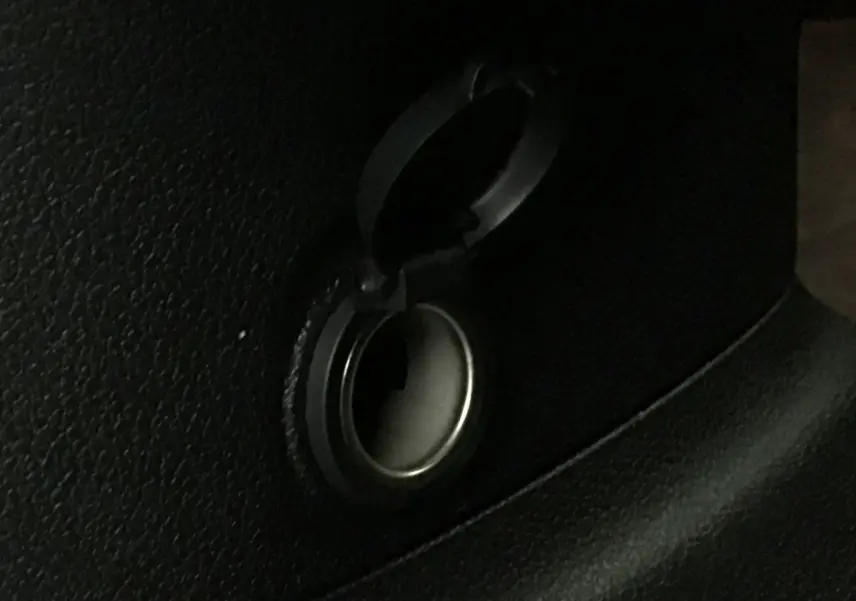 Prise allume-cigare noire ouverte dans l'habitacle du Peugeot Partner blanc 2025, vue en gros plan.