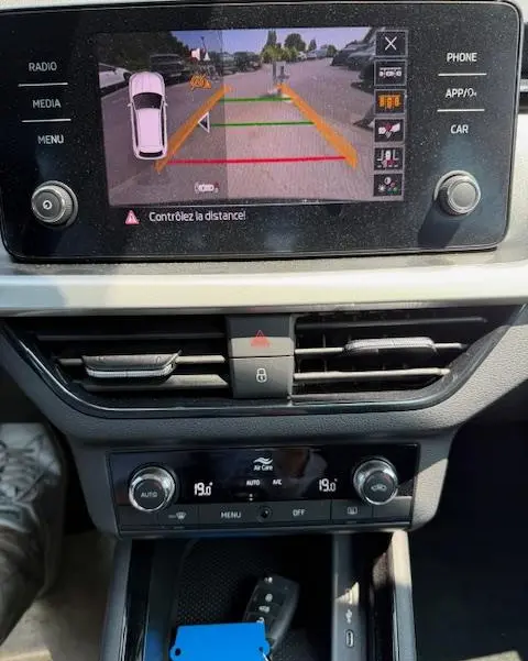 Vue rapprochée de l'écran tactile central affichant la caméra de recul du Skoda Kamiq noir 2024 avec commandes climatisation en dessous.