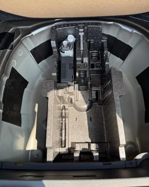 Vue plongeante sur le rangement sous tablette du coffre du Skoda Kamiq noir 2024, espace pour roue galette et outils.