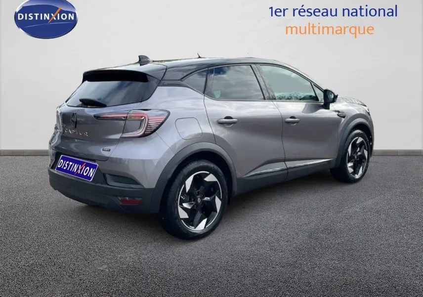 Vue 3/4 arrière droite d'un Renault Captur gris Cassiopée métal avec toit noir, roues noires et détails modernes.