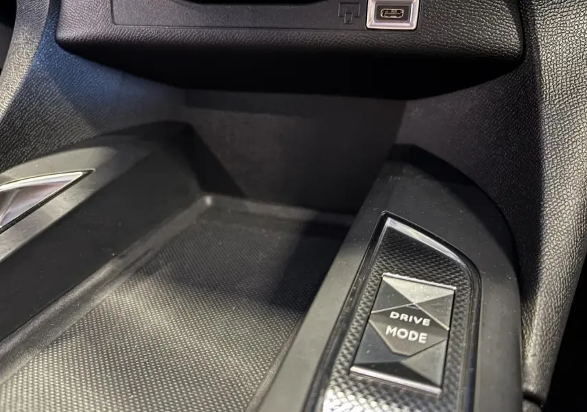 Gros plan sur la console centrale du DS3 Crossback 2024, bouton Drive Mode et port USB-C visibles, intérieur noir.