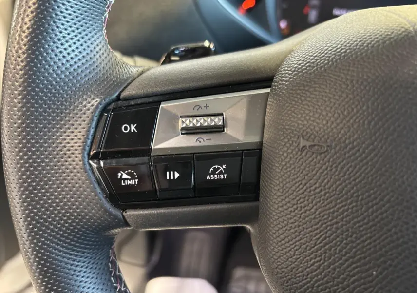 Gros plan sur les commandes au volant côté gauche du DS3 Crossback 2024 en cuir perforé noir.