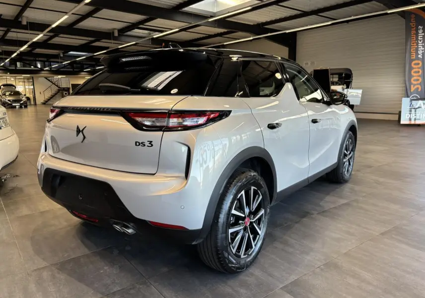 Vue 3/4 arrière droite du DS3 Crossback 2024 en blanc Crystal Pearl avec toit noir et jantes alliage noires.