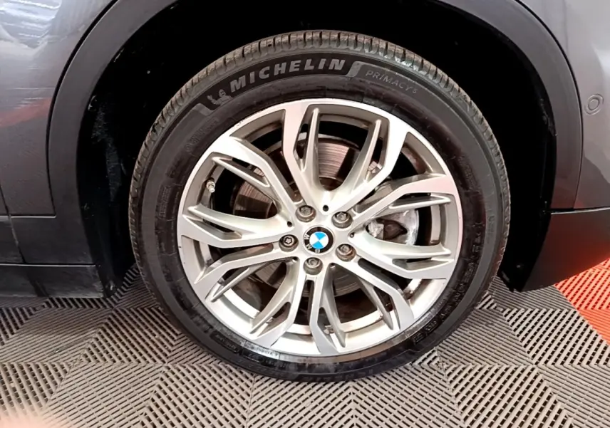 Gros plan sur la roue avant gauche grise d’un BMW X2 xDrive25e avec jante alliage et pneu Michelin.