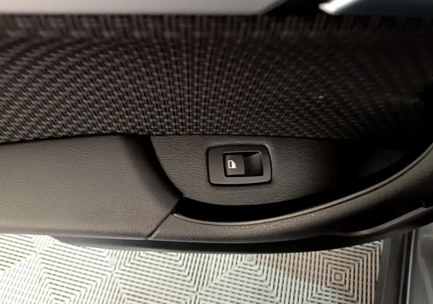 Bouton de verrouillage des portes sur la garniture intérieure noire d'une BMW X2 xDrive25e vue côté porte ouverte.