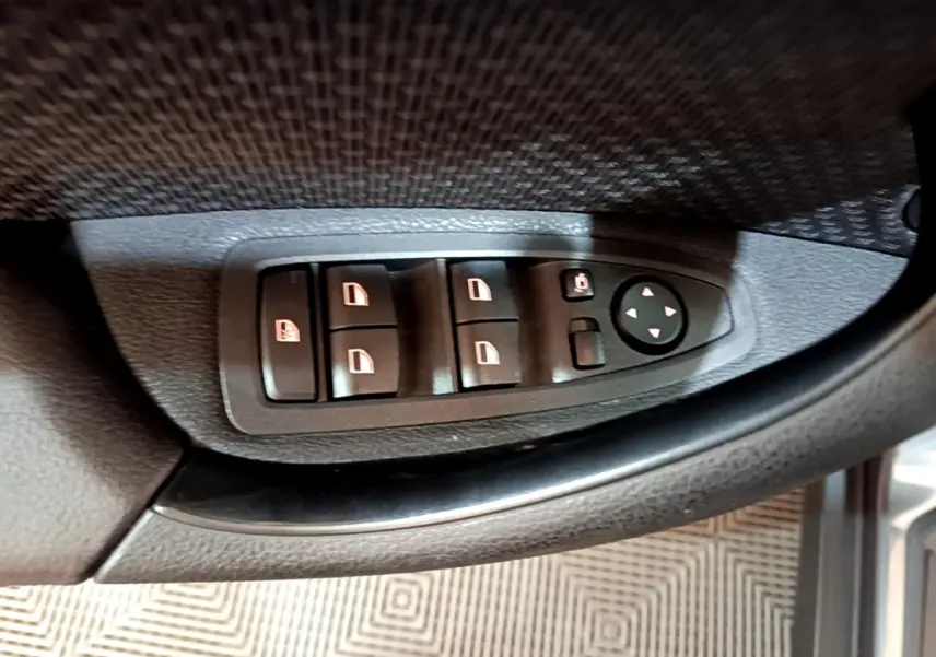 Gros plan sur les commandes de lève-vitres et rétroviseurs côté conducteur d'une BMW X2 hybride rechargeable 2020.