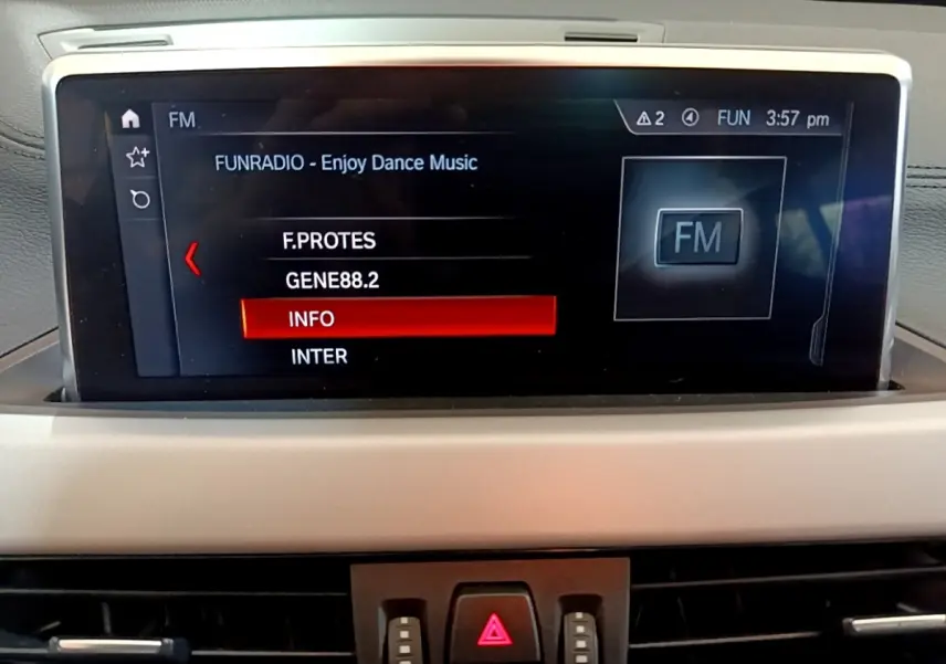 Écran tactile central de la BMW X2 xDrive25e 2020 affichant les stations radio FM dans l'habitacle gris.