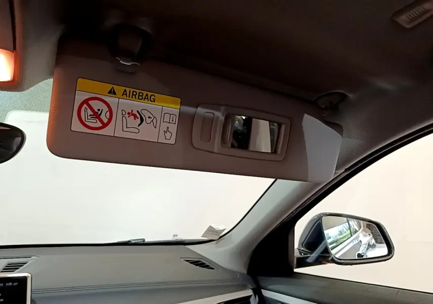 Vue intérieure côté conducteur du BMW X2 xDrive25e 2020, avec pare-soleil beige et rétroviseur latéral noir.