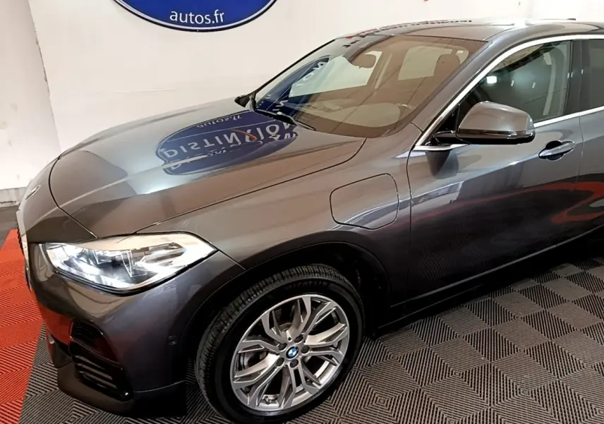 BMW X2 xDrive25e gris métallisé vue 3/4 avant droit, mettant en valeur les jantes alliage et les phares LED.