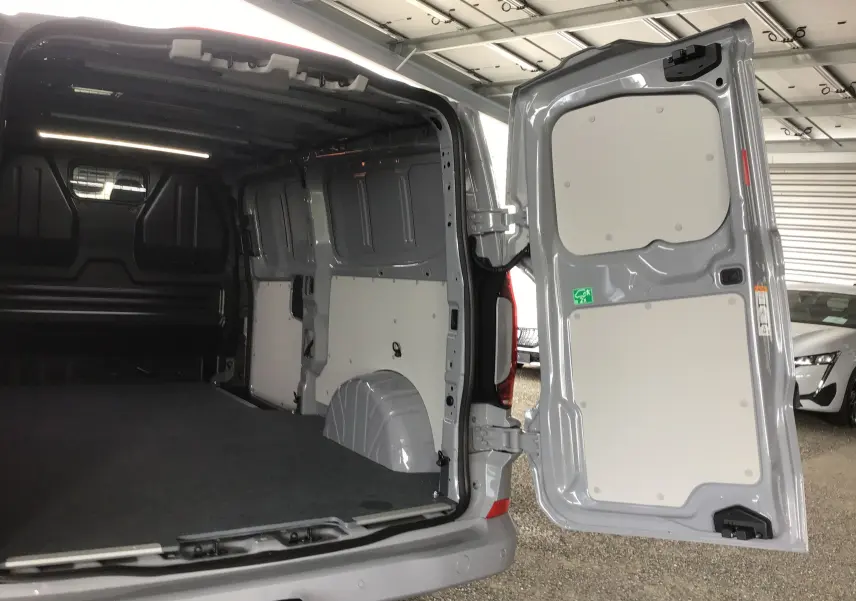 Vue arrière ouverte du Volkswagen Transporter T7 gris stone, montrant l'espace de chargement vide et les portes battantes.