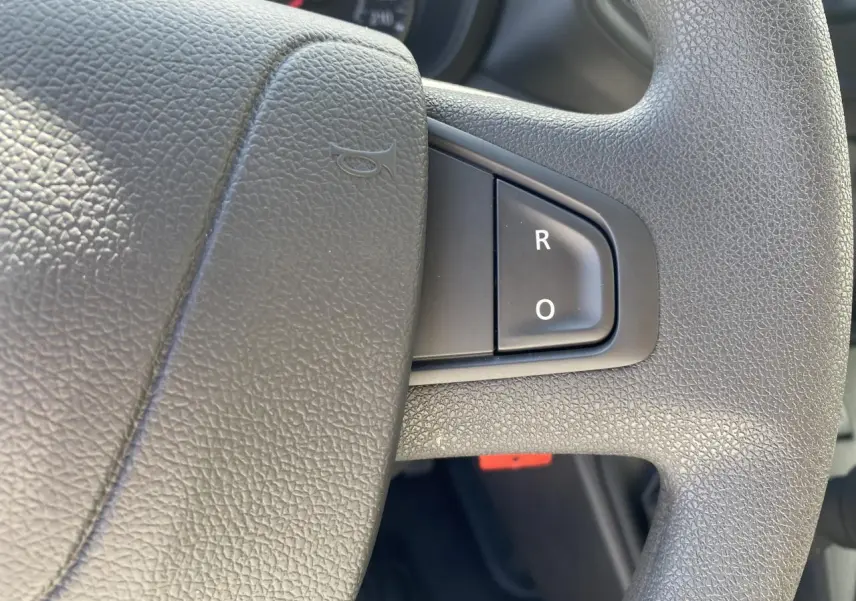 Gros plan sur le volant gris texturé du Nissan Interstar 2022 avec commandes au volant visibles.