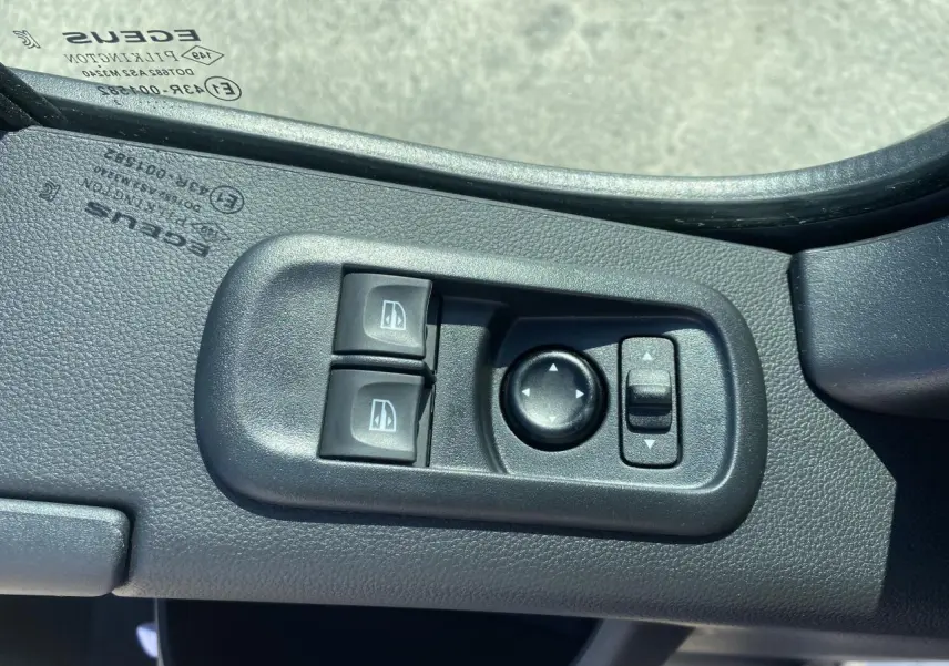 Gros plan sur les commandes des lève-vitres et réglage des rétroviseurs côté conducteur du Nissan Interstar blanc 2022.