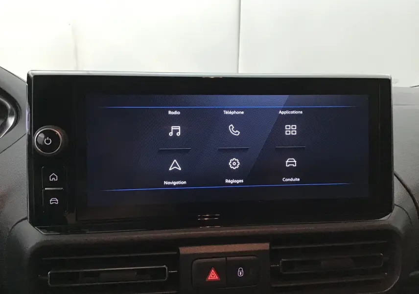 Écran tactile central affichant les options radio, téléphone, navigation et réglages dans un Peugeot Partner blanc.