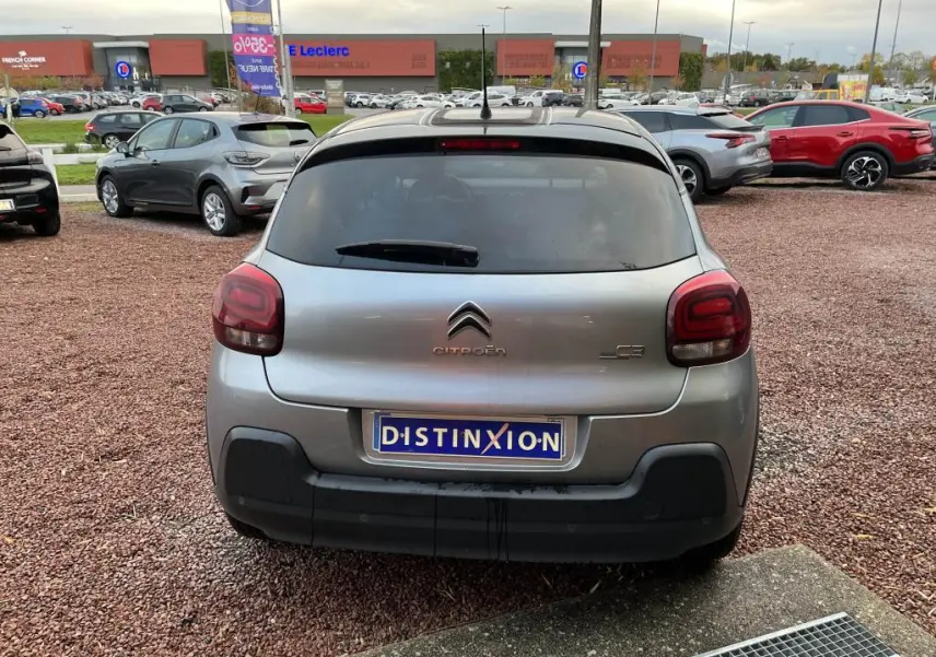 Vue arrière d'une Citroën C3 gris foncé de 2019 avec vitres surteintées et logo distinctif sur un parking.