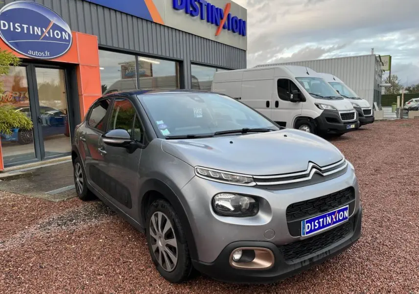 Citroën C3 gris foncé vue 3/4 avant droit, avec stickers Origins sur portes et coques de rétroviseurs noires.
