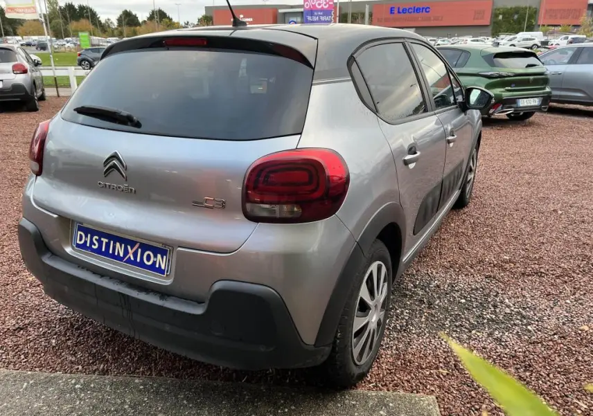 Citroën C3 gris foncé vue 3/4 arrière droit, avec adhésifs Origins sur portes et toit noir contrasté.