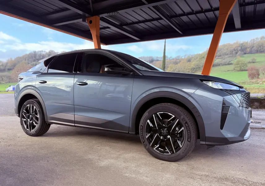Peugeot 3008 Hybrid 136ch Allure bleu Ingaro métal en vue profil côté gauche sous abri avec jantes noires distinctives.