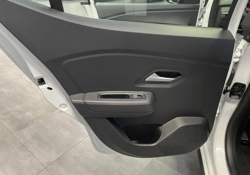 Vue intérieure de la porte arrière gauche noire avec poignée argentée de la Dacia Sandero Stepway blanc glacier 2025.