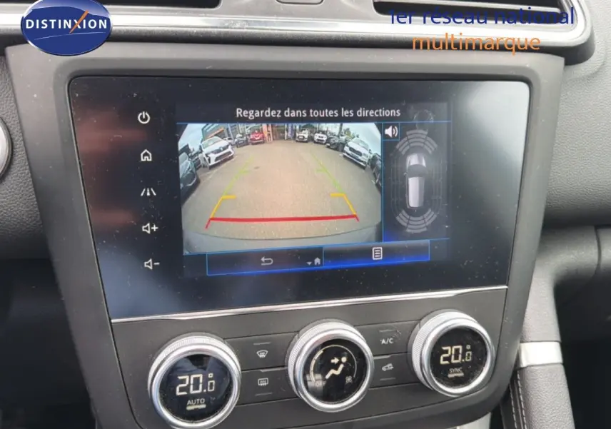 Vue rapprochée de l'écran tactile intérieur du Renault Kadjar bleu Iron, affichant la caméra de recul et la climatisation à 20°C.