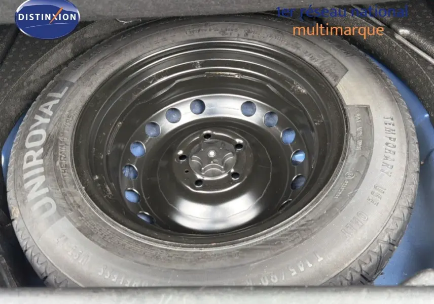 Roue de secours noire montée sur jante acier, logée dans le coffre d’un Renault Kadjar bleu Iron.