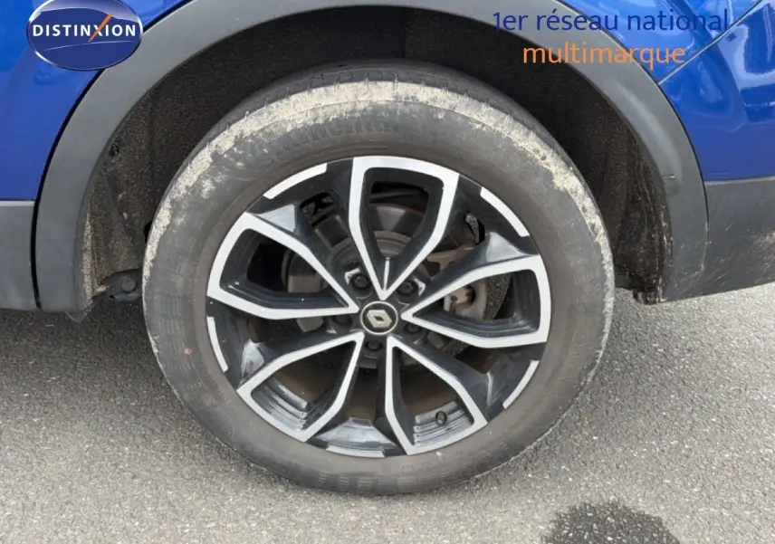 Gros plan sur la roue avant gauche du Renault Kadjar bleu Iron, mettant en valeur la jante alliage noire et argentée.