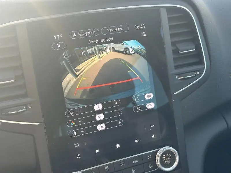 Écran tactile central montrant la caméra de recul d’une Renault Mégane Break gris titanium, intérieur noir.
