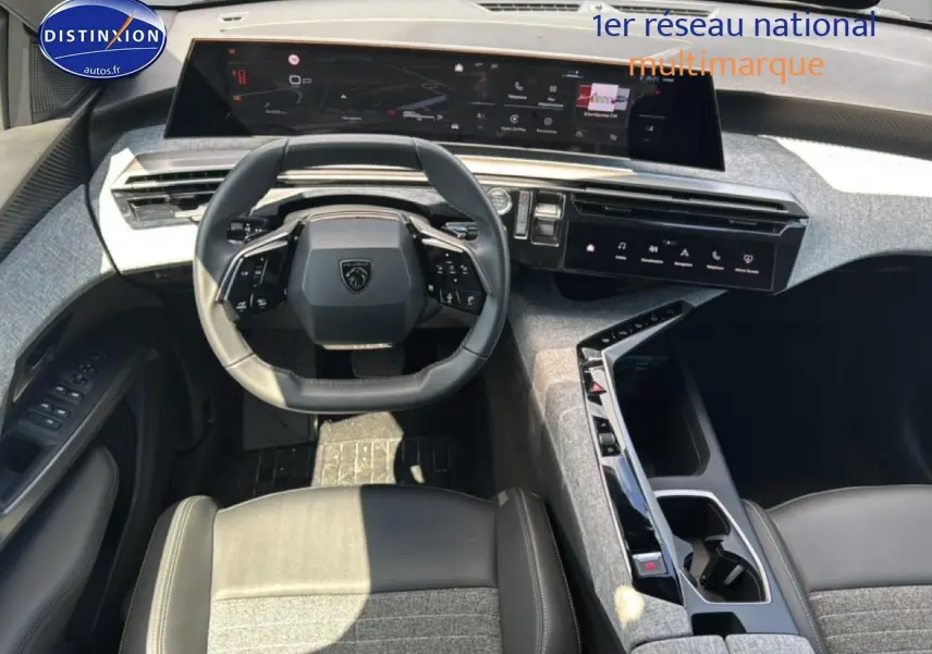 Vue intérieure du poste de conduite du Peugeot 5008 Hybrid 145 allure e-dcs6 2025 avec volant cuir et écran tactile panoramique.