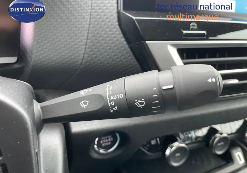 Gros plan sur la commande d’essuie-glace à gauche du tableau de bord d’une Citroën C4 blanche 2024.