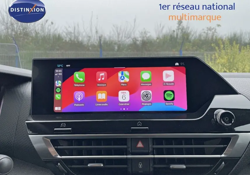 Écran tactile central allumé avec interface Apple CarPlay dans le tableau de bord d'une Citroën C4 blanche 2024.