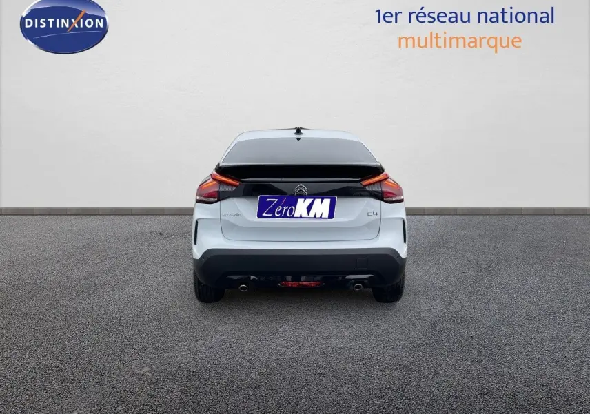 Vue arrière d'une Citroën C4 blanche métal 2024 avec feux LED et double sortie d'échappement visible.