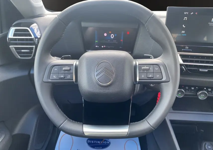 Volant cuir noir de la Citroën C4 Nouvelle Plus Hybrid 136 e-DCS6 avec tableau de bord numérique et écran tactile central.