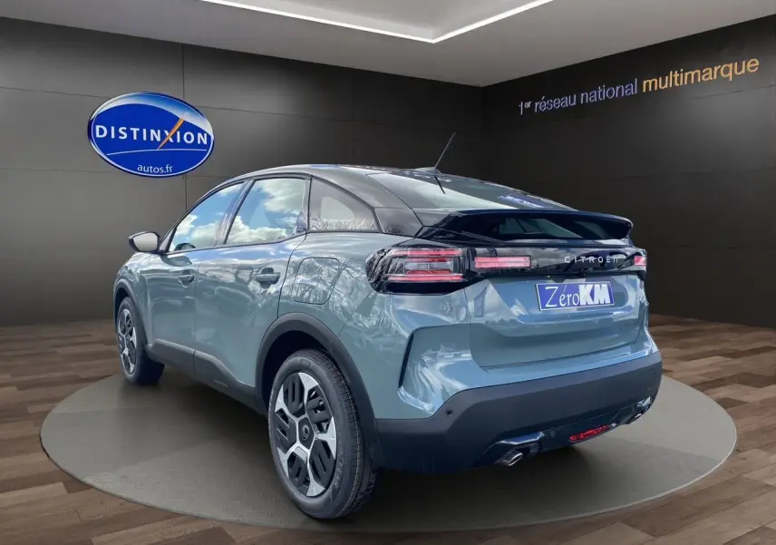 Vue 3/4 arrière droite d'une Citroën C4 2025 Manhattan Green avec toit noir et feux arrière LED distinctifs.