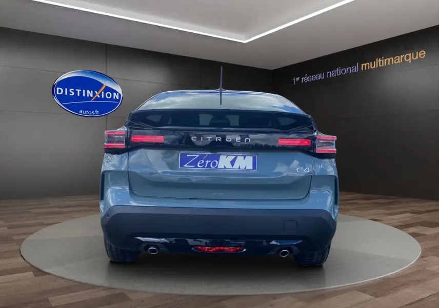 Vue arrière d'une Citroën C4 Manhattan Green avec toit noir, feux LED et double sortie d'échappement visibles.