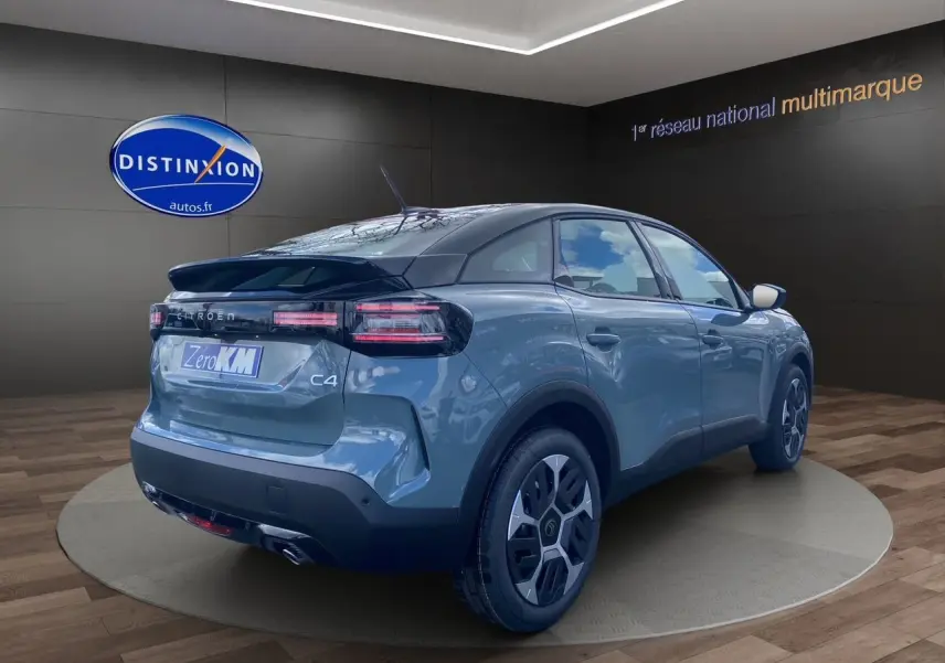 Vue 3/4 arrière droite d'une Citroën C4 2025 Manhattan Green avec toit noir et jantes Aerotech 18 pouces.