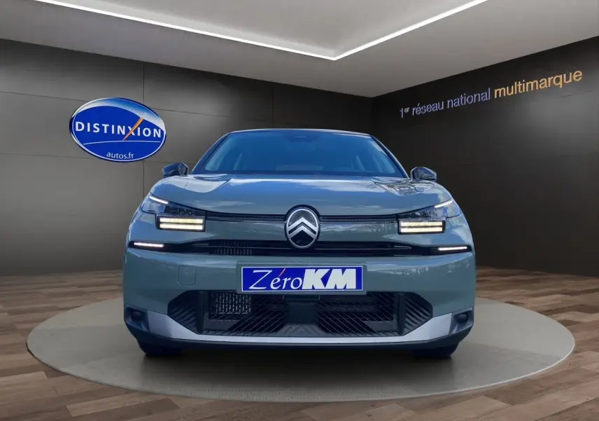 Vue avant d'une Citroën C4 2025 Manhattan Green avec feux LED et calandre noire dans un showroom.