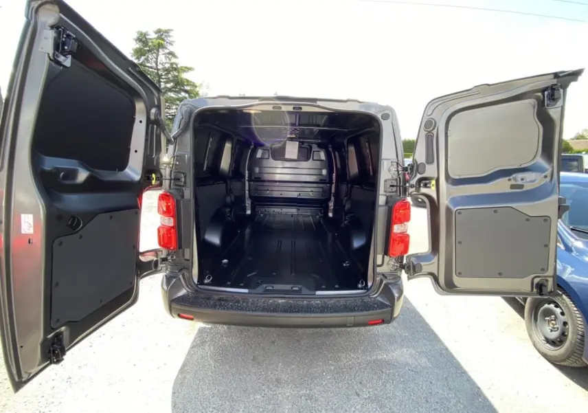 Vue arrière ouverte du Peugeot Expert Fourgon gris platinium 2022 montrant l'espace de chargement tôlé et vide.