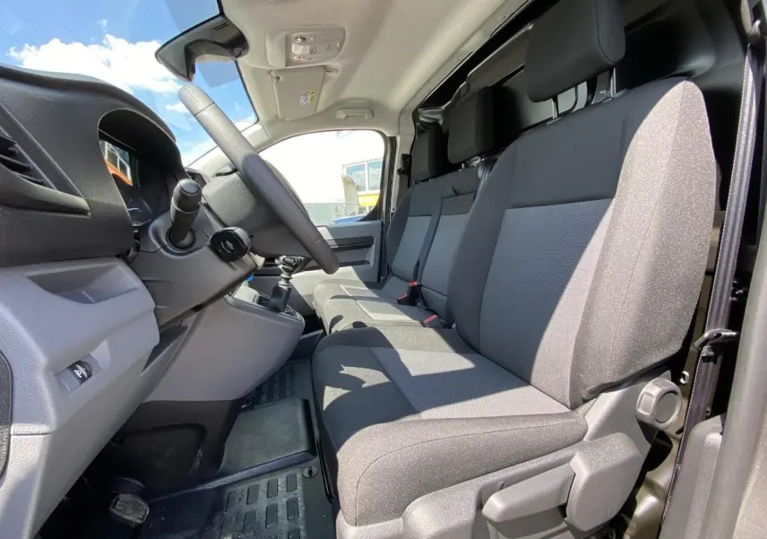 Vue intérieure côté conducteur du Peugeot Expert Fourgon 2022 avec banquette Moduwork en tissu gris.