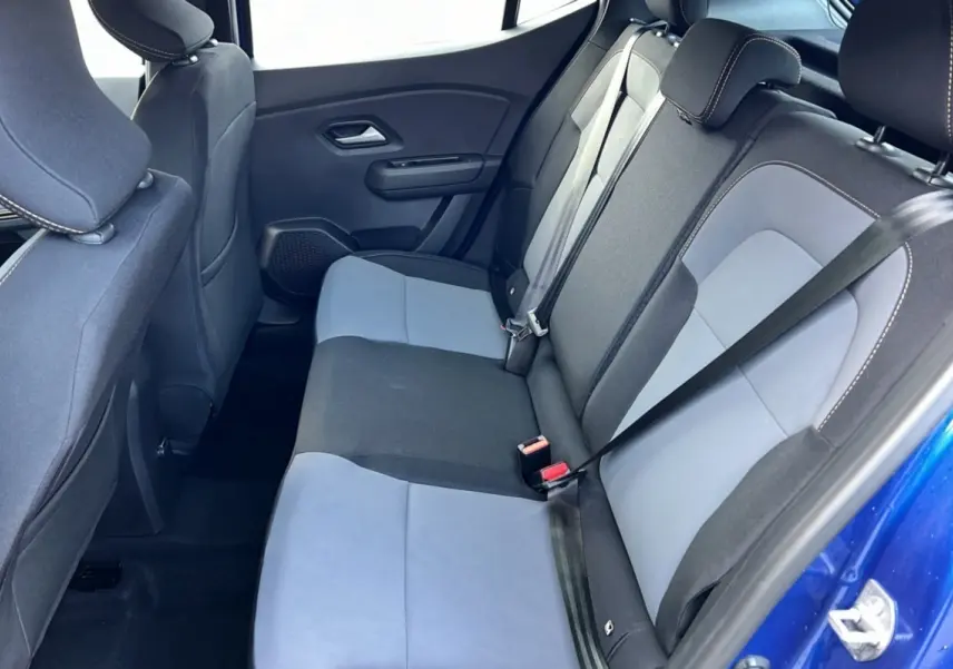 Vue intérieure arrière montrant les sièges arrière bicolores gris et noir du Dacia Sandero Stepway Bleu iron 2024.