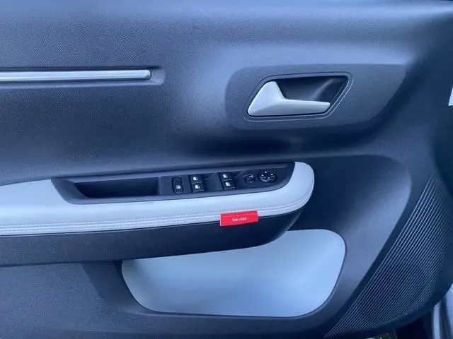 Vue rapprochée de la porte avant gauche du Citroën C3 Aircross gris Mercury avec insert noir et bouton "be cool" rouge.