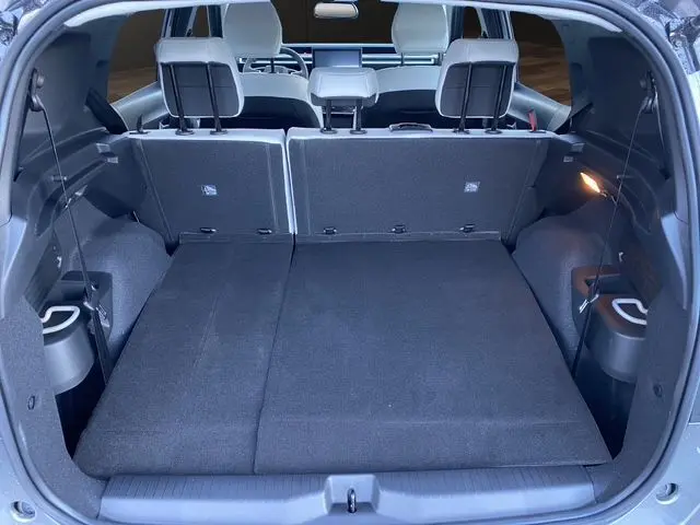 Vue intérieure du coffre du Citroën C3 Aircross gris Mercury, sièges arrière rabattus et détails en tissu noir.