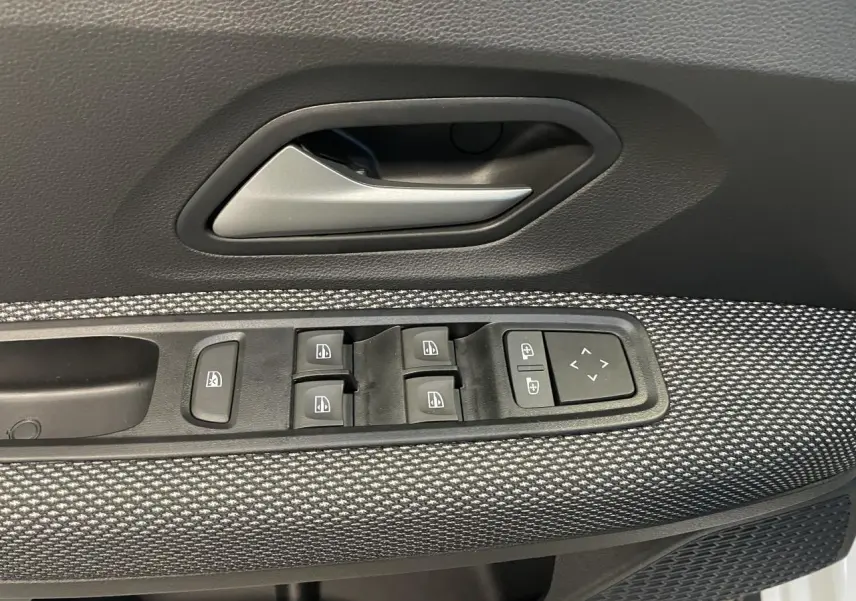 Gros plan sur la commande des vitres électriques côté gauche d'une Dacia Sandero Stepway blanc glacier 2025.