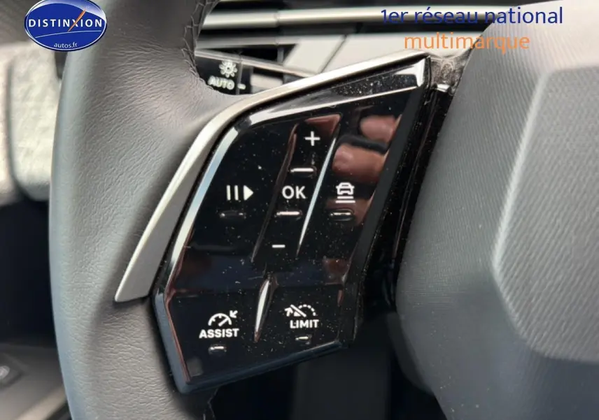Gros plan sur les commandes au volant noir du Peugeot 5008 Hybrid 145 allure e-dcs6 2025, côté gauche.