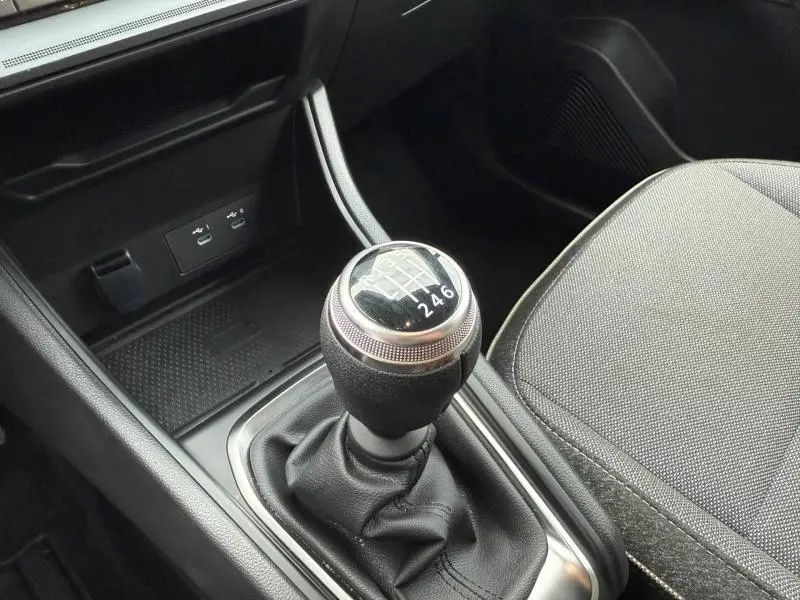 Gros plan sur le levier de vitesses manuel du Renault Captur 2025, intérieur noir avec siège tissu gris.