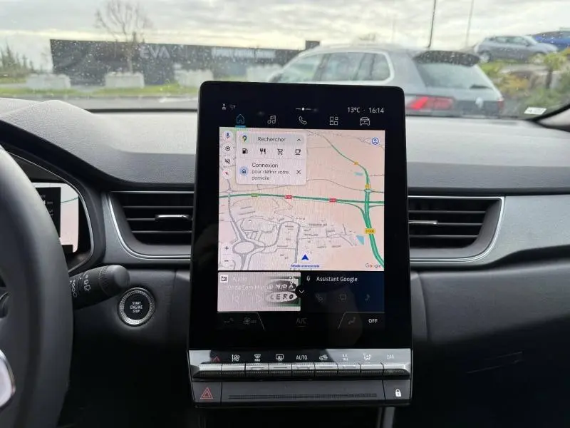 Vue intérieure du tableau de bord du Renault Captur 2025 avec écran tactile central affichant une carte de navigation.