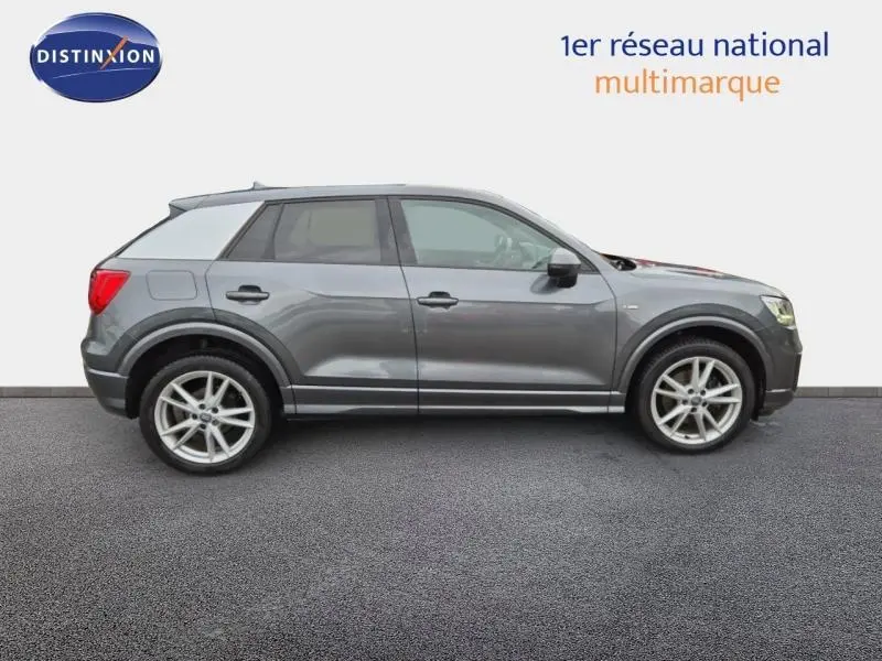 Audi Q2 gris Manhattan vue de profil côté gauche, mettant en valeur ses jantes alliage et lignes sportives.